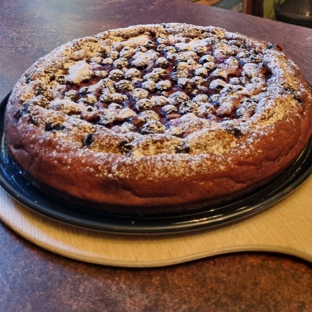 fertige Quarktorte mit Blaubeeren und Puderzucker